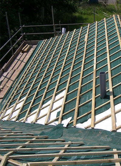Roofers laying roof tiles